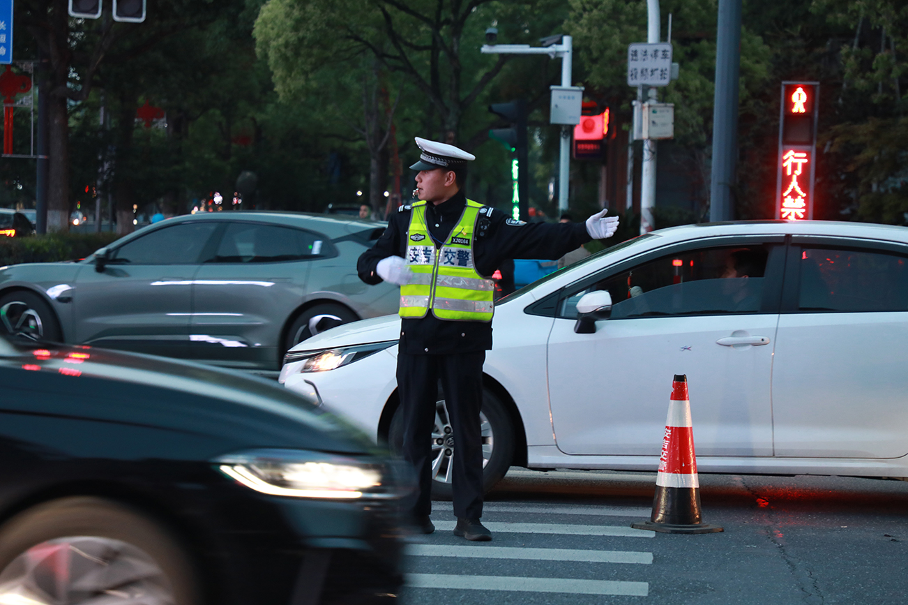 安吉县公安局交警大队组织警力在晚高峰引导、疏通过往车辆.jpg