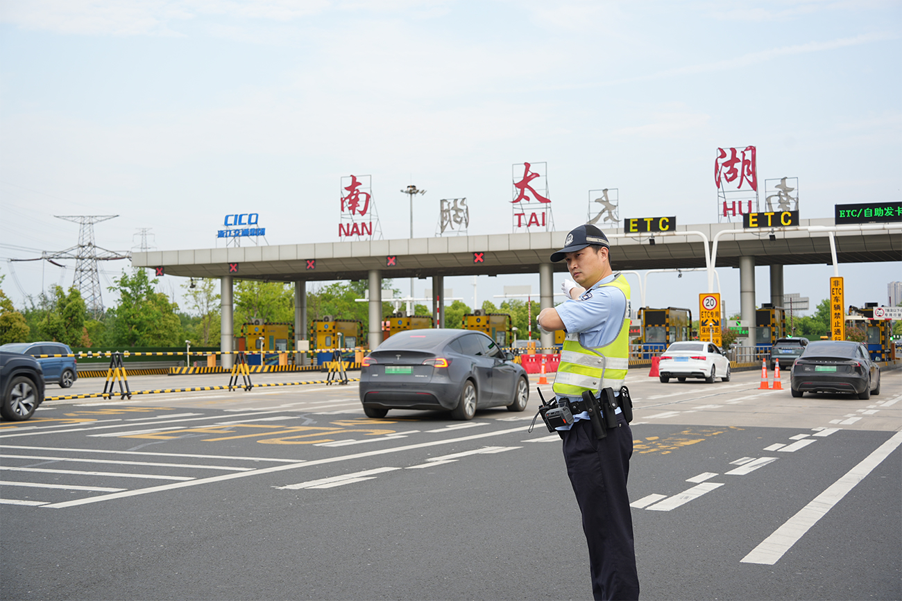 湖州高速交警在G50高速收费站引导、疏通过往车辆.jpg